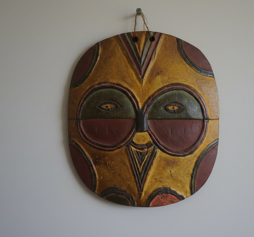 Traditional wooden mask with colorful design on a white background