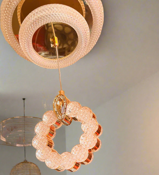 Chandelier on display with a red wall featuring decorative items.