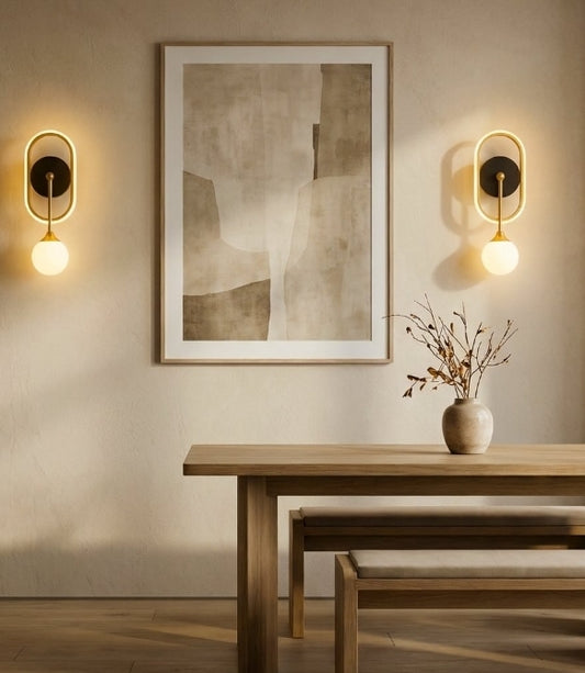 Dining room with wooden table, abstract art, and wall lights.