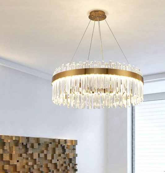 Amangazini Gleaming Crystal Cylinder Chandelier with gold frame hanging in modern living room
