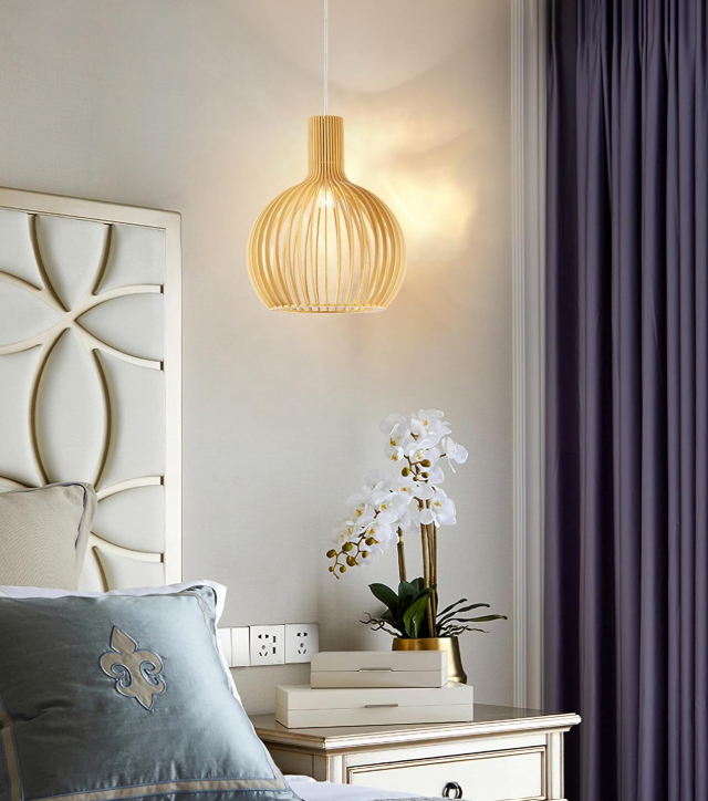Amangazini handcrafted wood light pendant hanging above a bedside table with an orchid arrangement
