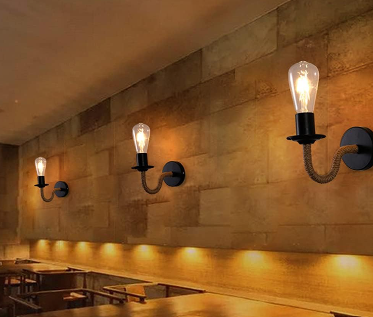 Amangazini Industrial Rope Arm Wall Sconce with exposed bulbs mounted on a rustic brick wall