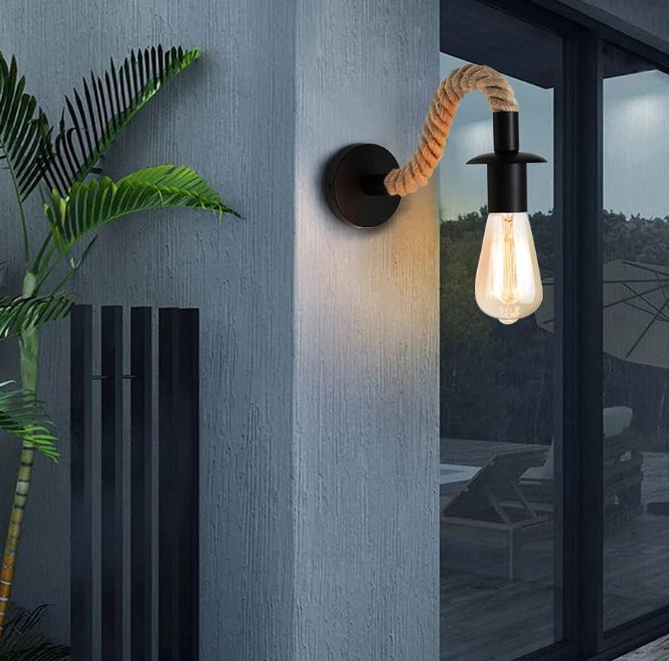 Amangazini Industrial Rope Arm Wall Sconce with exposed bulb and natural rope arm mounted on textured gray wall
