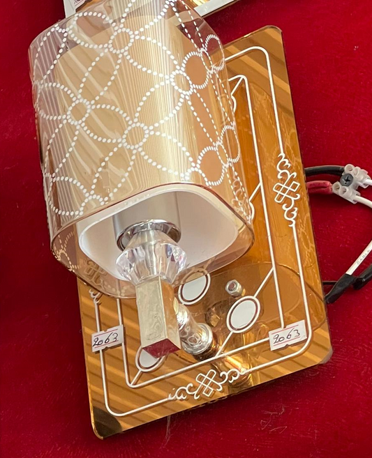 Elegant modern crystal wall light with decorative shade and gold mounting plate for stylish interior decor