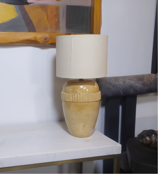 Lamp with a beige shade and base on a white surface
