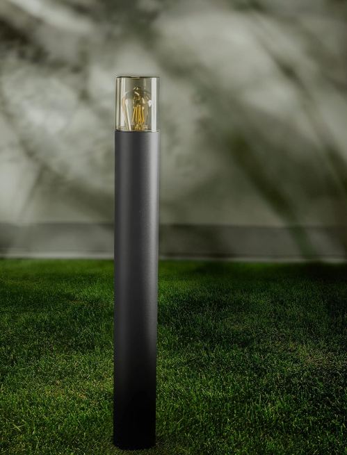 Amangazini Sentinel Bollard Light with sleek black finish and glass top illuminating outdoor grass area