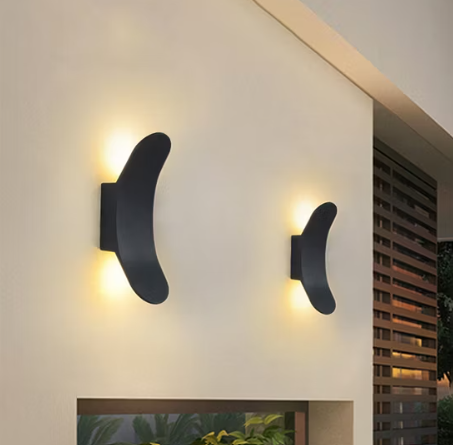 Stylish bow wall sconce in black finish illuminating a contemporary exterior wall