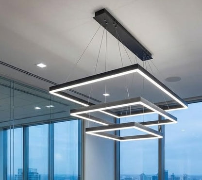 Modern pendant light fixture hanging in an office with large windows.