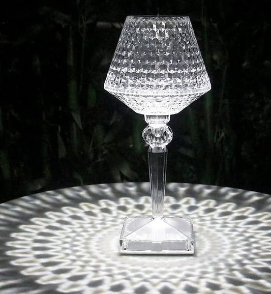 Crystal table lamp casting a pattern on a dark background