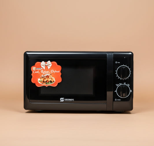 Black microwave oven with a label on a blurred store shelf background