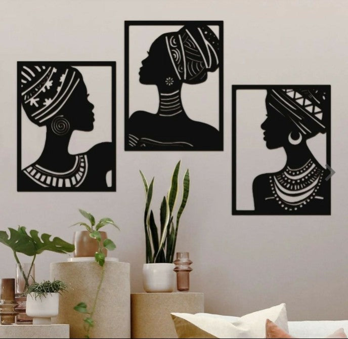 Three black and white silhouette wall art pieces of women on a light gray wall.