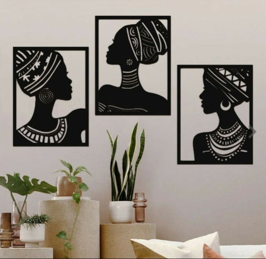 Three black and white silhouette wall art pieces of women on a light gray wall.