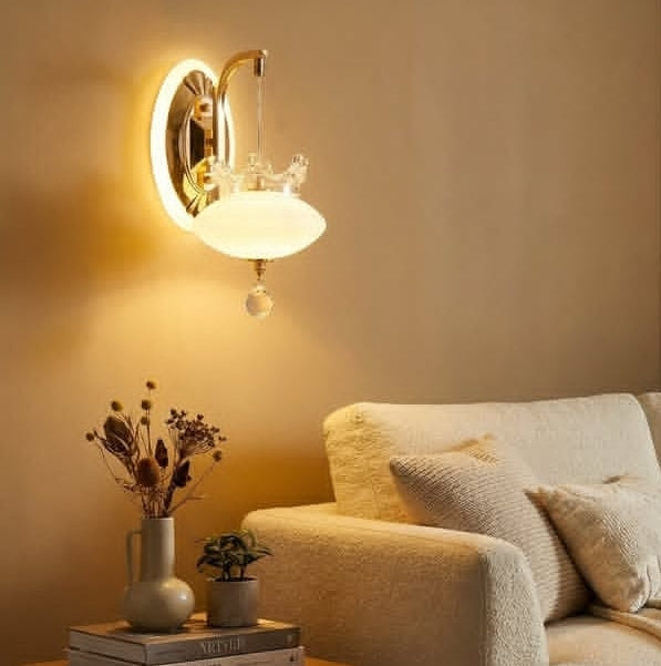 Wall-mounted lamp casting a warm glow on a cozy living room setting with a sofa and decorative items.