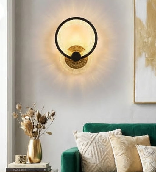 Wall-mounted lamp in a living room with a green sofa and decorative pillows.