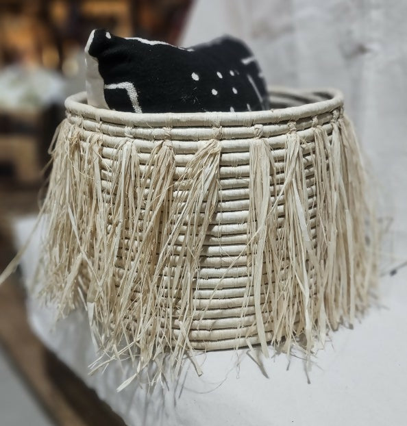Woven basket with tassels on a blurred background