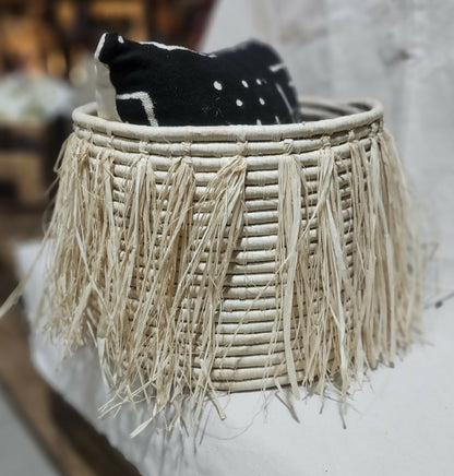 Woven basket with tassels on a blurred background