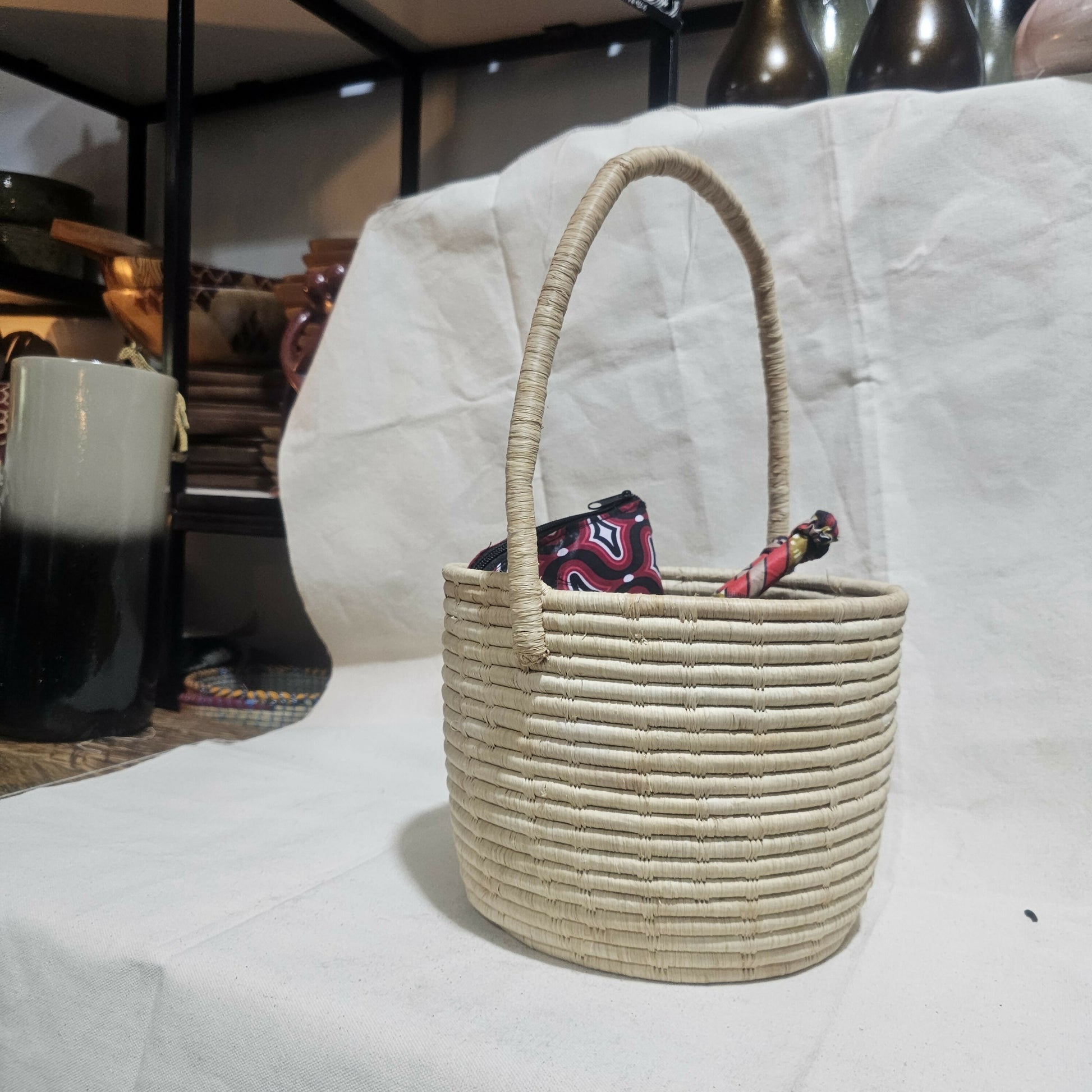 Woven basket with a handle on a white surface