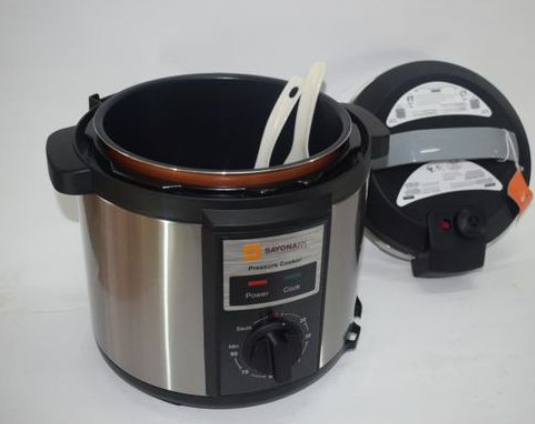 Pressure cooker with a spoon inside on a white background