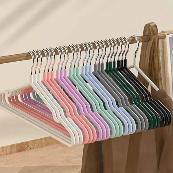 Set of colorful hangers on a wooden rack against a neutral wall.
