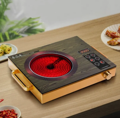 Portable electric stove with a glowing red heating element on a wooden table.