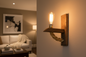 Wooden wall sconce with a light bulb in a living room setting