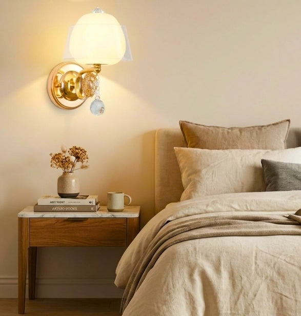 Bedroom with a wall sconce, nightstand, and bed with pillows.