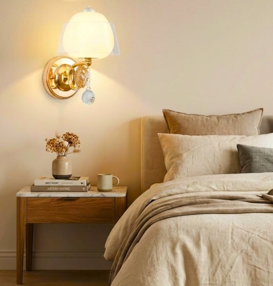 Bedroom with a wall sconce, nightstand, and bed with pillows.