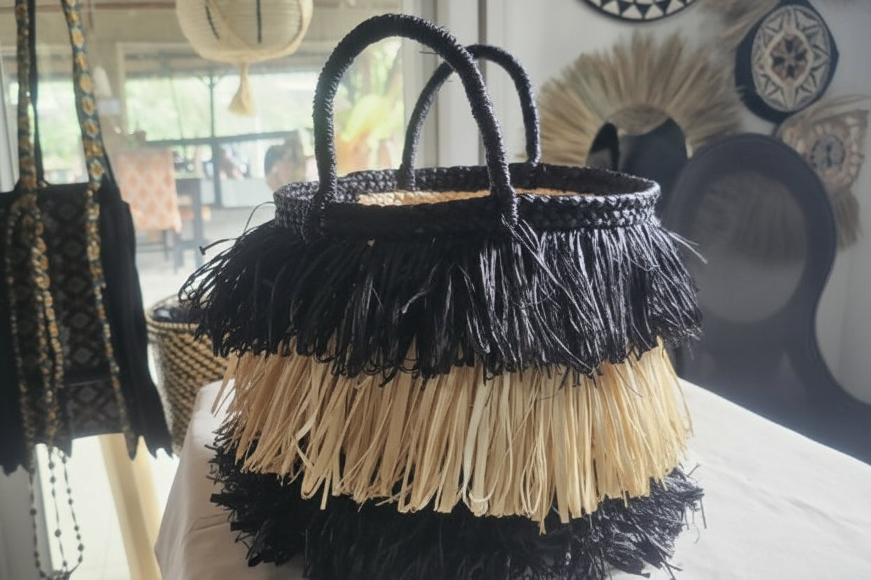 Woven basket with black and beige fringe on a table
