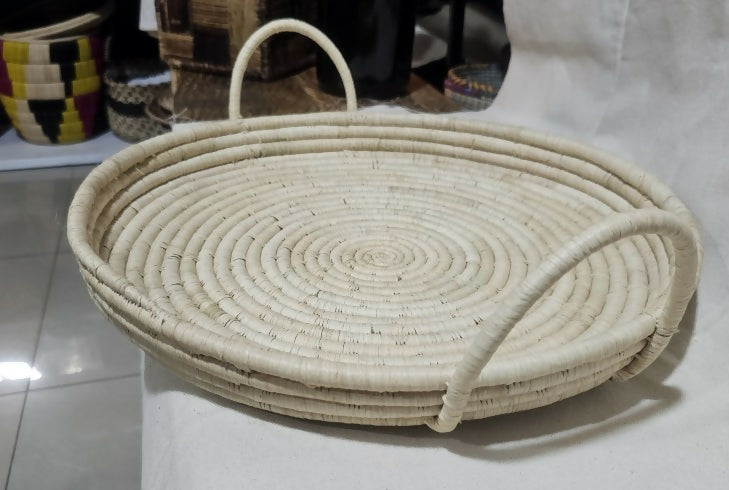 Woven basket with handles on a white surface