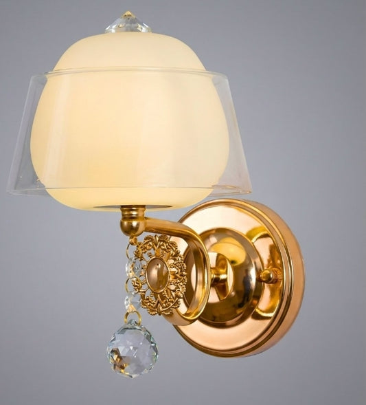 Gold wall sconce with a white glass shade on a gray background