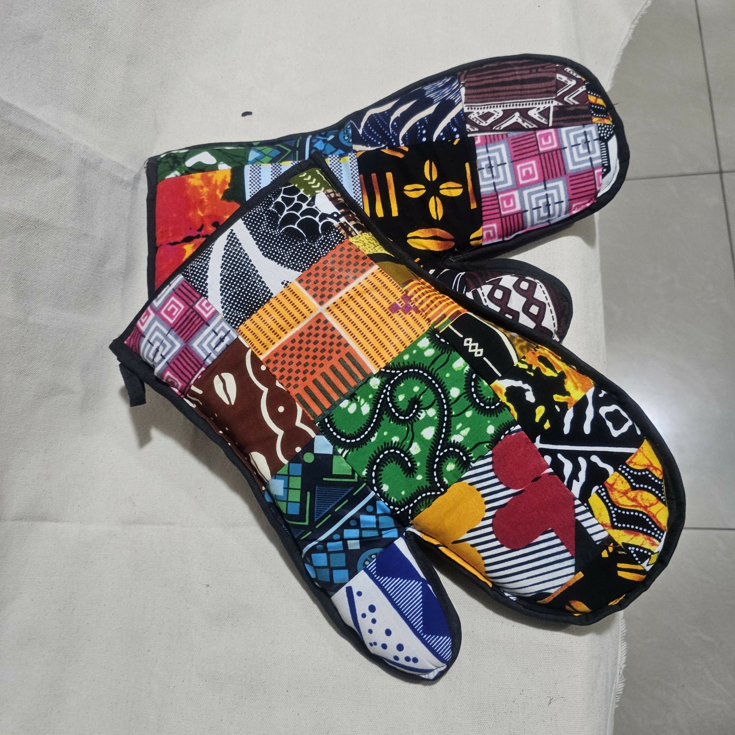 Colorful patterned oven mitts on a light background
