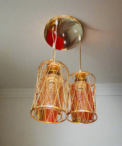 Gold pendant lights hanging from a ceiling with a wall in the background
