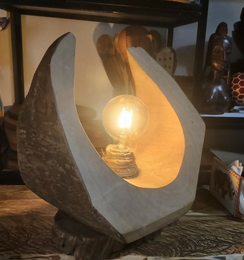 Decorative lamp with a light bulb inside, resembling a stone or natural material.
