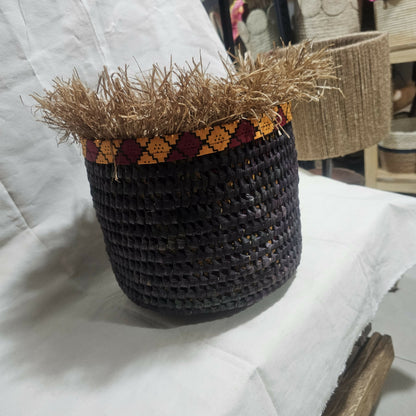 Woven basket with straw top on a white surface