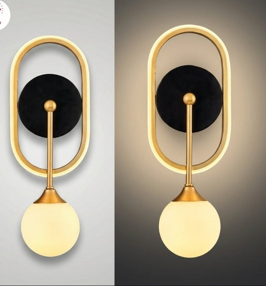 Modern wall sconce with gold frame and black disc on a gray background