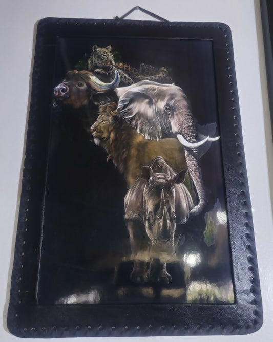 Framed artwork with a lion, elephant, and other animals on a dark background
