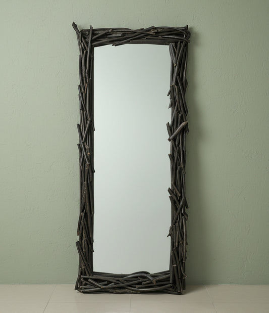 Decorative mirror with natural frame in a room with plants and a fish tank.