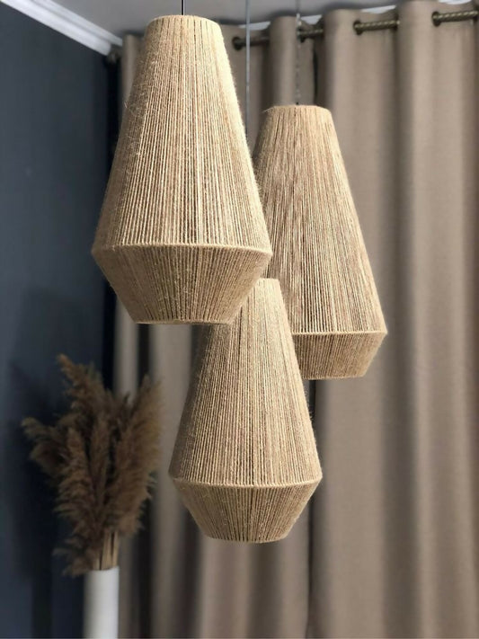 Three woven pendant lights hanging against a neutral background