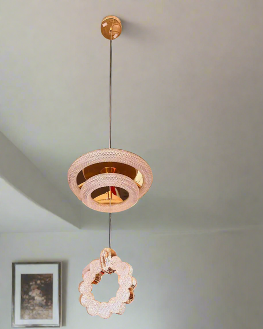Modern pendant light fixture hanging from a ceiling with a neutral background.