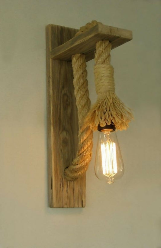Wooden wall sconce with rope design and exposed light bulb on a plain background