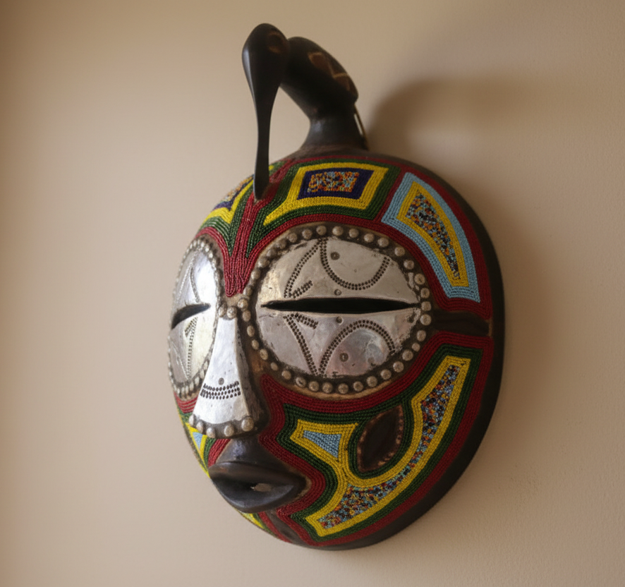 Decorative mask with colorful patterns on a beige wall