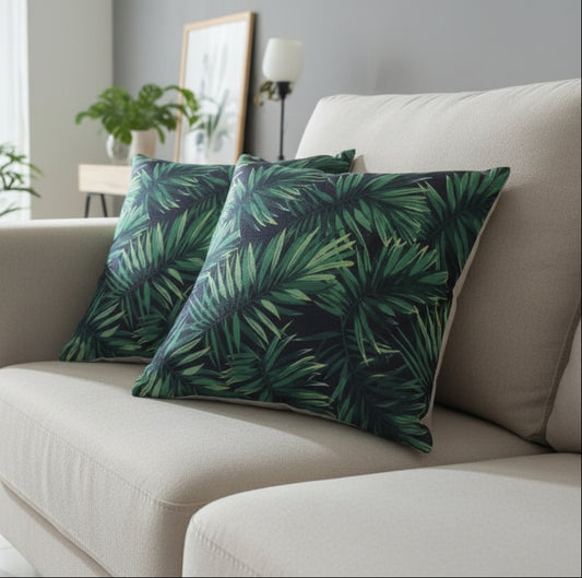 Two green leaf-patterned cushions on a white surface