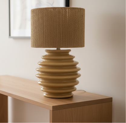 Decorative lamp with a textured brown shade and ribbed base on a white surface.