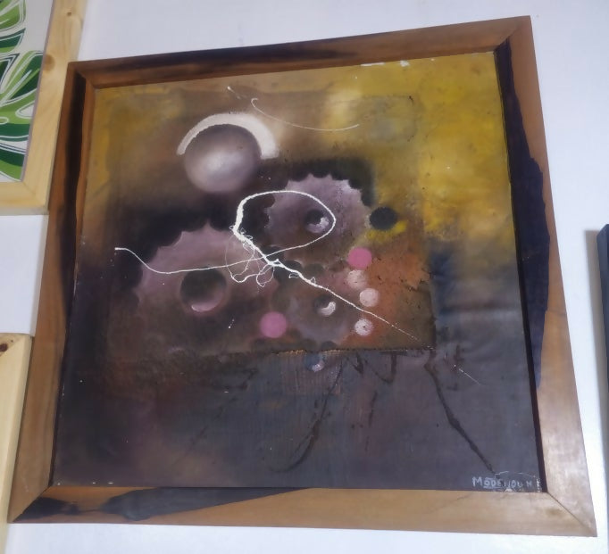 Abstract painting with colorful circles in a wooden frame.
