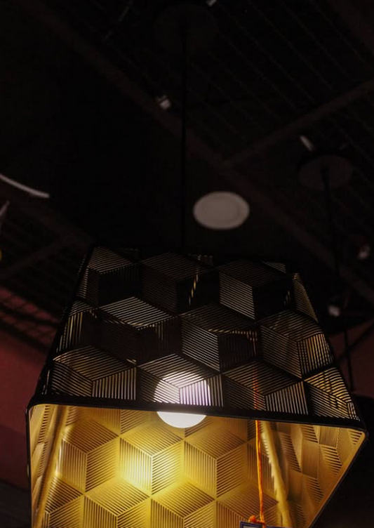 Gilded Cage Pendant Light with a geometric design illuminating a cozy interior space