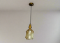 Amangazini golden cage pendant light with a vintage glass shade and brass detailing hanging from the ceiling