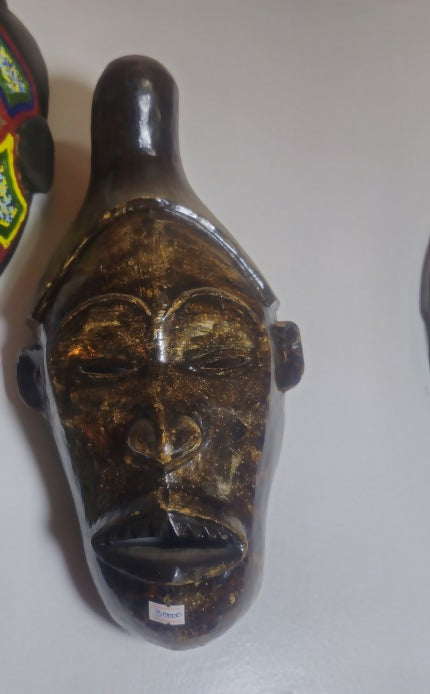 Decorative mask with intricate designs on a plain background