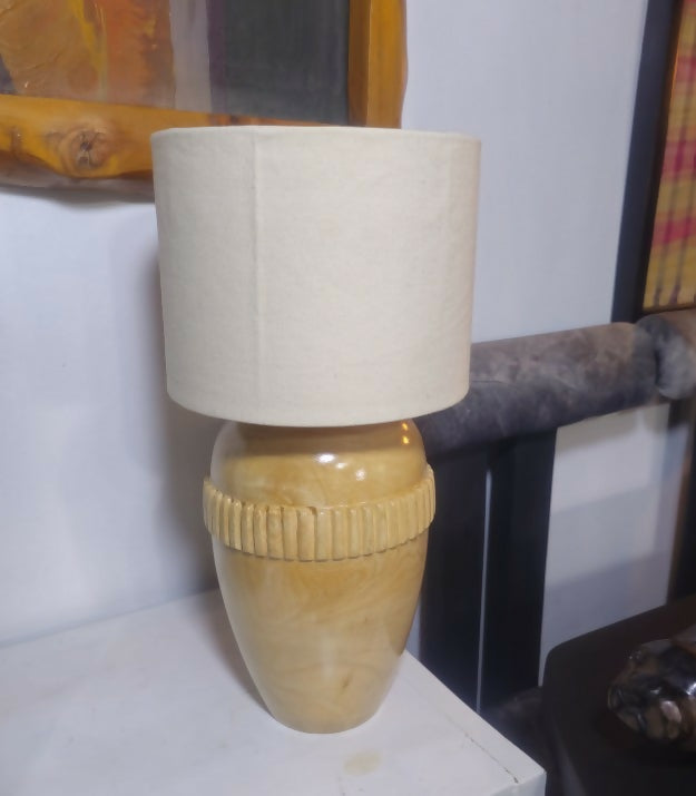 Lamp with a beige shade and base on a white surface