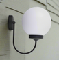 Spherical modern wall globe light fixture with a white glass shade and stylish black arm