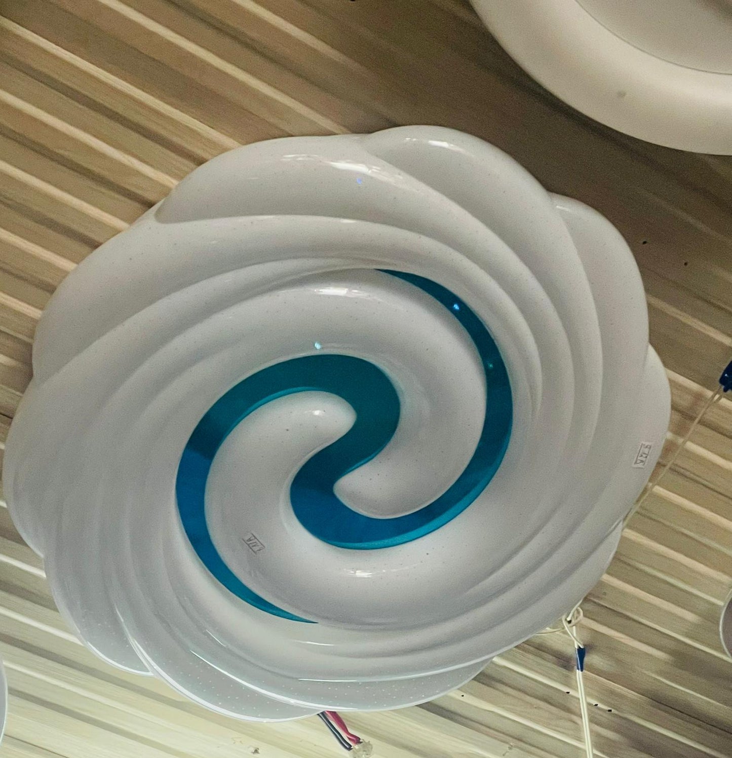 Teal swirl ceiling light featuring a modern design with a striking blue and white color contrast